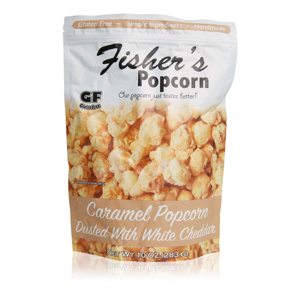 A 10oz bag of Fisher’s Popcorn Cheddar Dusted Caramel Popcorn, in white and brown packaging with popcorn images, labeled gluten free, handmade, and made with simple ingredients.