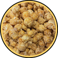 A close-up of Fisher's Popcorn Caramel Dusted w/ White Cheddar shows golden popcorn coated in caramel and lightly dusted with savory white cheddar inside a circular yellow-and-black frame.