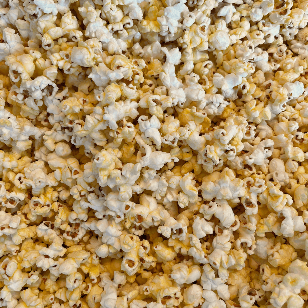 A close-up of fluffy yellow and white kernels packed together, just like the delicious popcorn in Fisher’s Popcorn Tubs by Fisher's Popcorn.