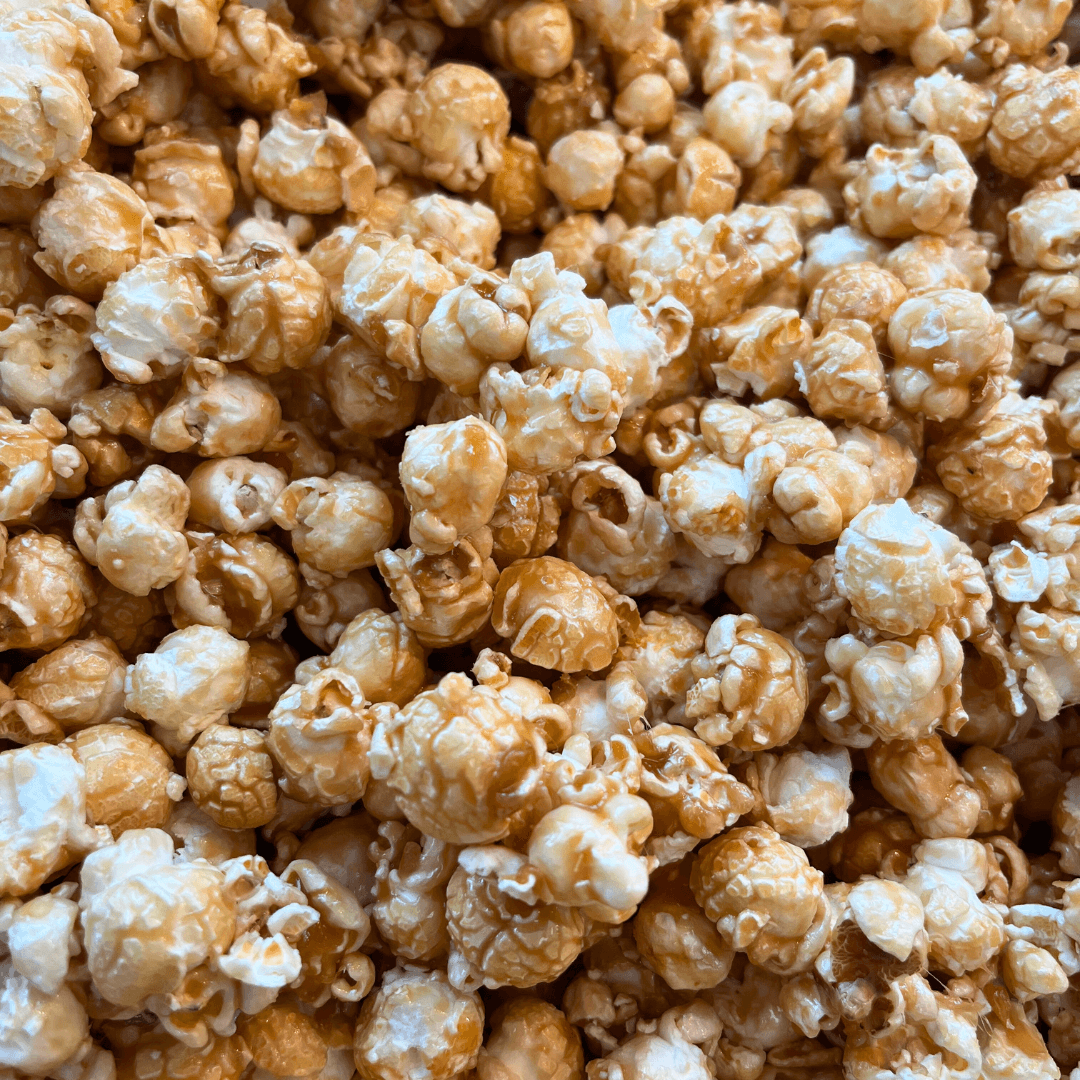 Close-up of Fisher’s Popcorn Tubs—fluffy white kernels coated in golden caramel, perfect for sharing this classic treat from Fisher’s Popcorn.