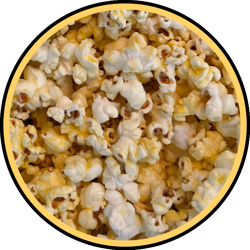 A close-up of fluffy white popcorn coated in Fisher's Popcorn Sm Xmas Butter Flavored, framed by a yellow and black circular border.