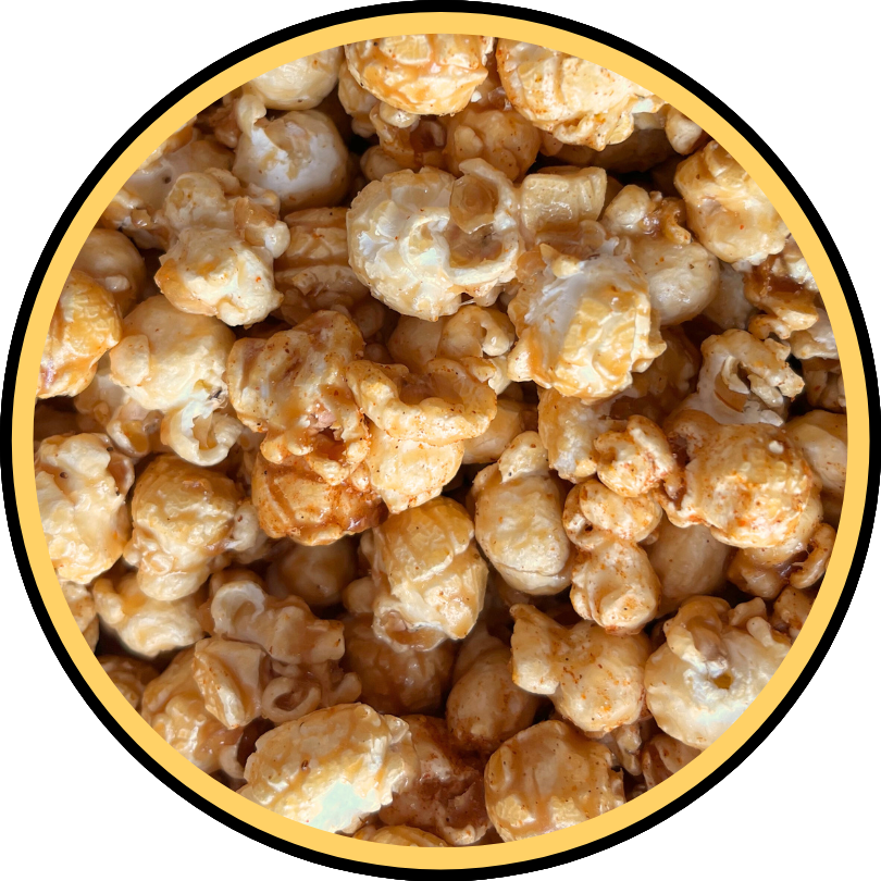 A close-up of Fisher's Popcorn Sm Xmas OLD BAY® Seasoned Caramel shows golden-brown popcorn clusters coated in shiny caramel, framed by a yellow and black circular border—the perfect festive treat for your Holiday Tub.